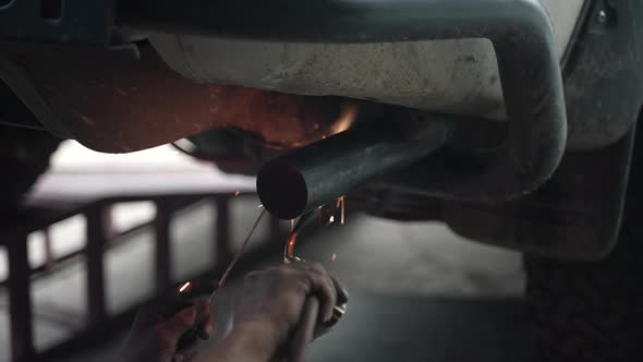 blacksmith welder works with metal steel and iron using a welding machine, bright sparks and flashes alt