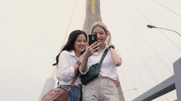 Happy Asian lesbian couples selfie video chat with friends enjoying traveling in Thailand.