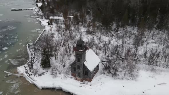 Drone view of Grand Island East Chanel Lighthouse during winter in Munising, Michigan. alt