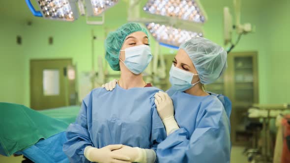 Happt Female Doctors After Successful Operation in Medical Face Masks, Gloves and Caps in Surgery alt