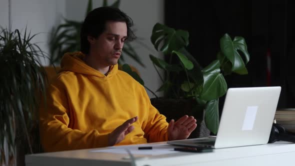 Man working at home office at laptop and make a breath exercises alt