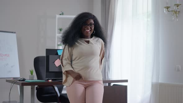 Joyful African American Young Woman Dancing in Slow Motion in Office Indoors Smiling alt