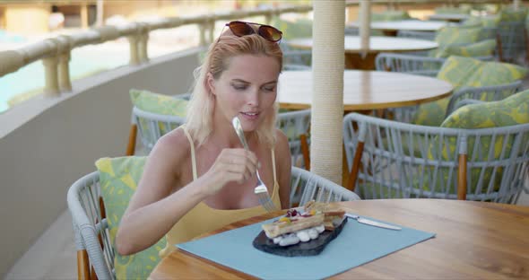 Happy Woman Enjoying Tropical Dish in Restaurant alt