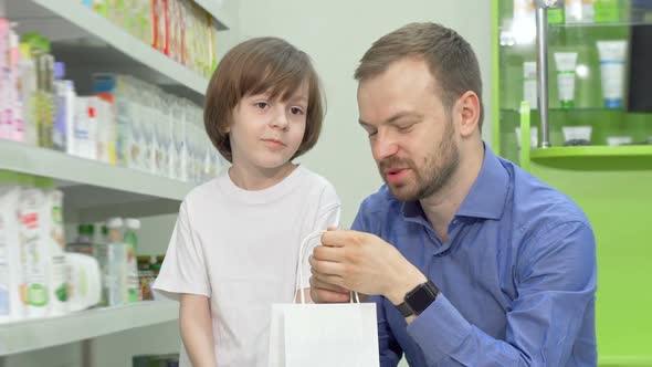 Mature Man Shopping at Drugstore with His Little Son