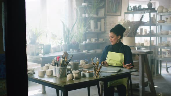 Woman Is Using Laptop In Pottery Studio