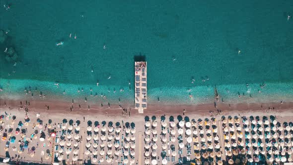 Aerial Top View of Beach with Sunshade and People Swimming at Beautiful Blue Color Sea alt