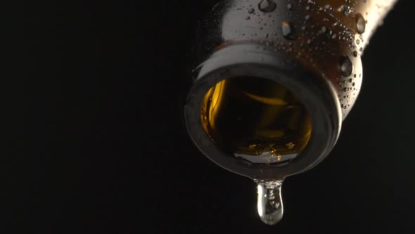 Wet beer bottle neck with falling drops