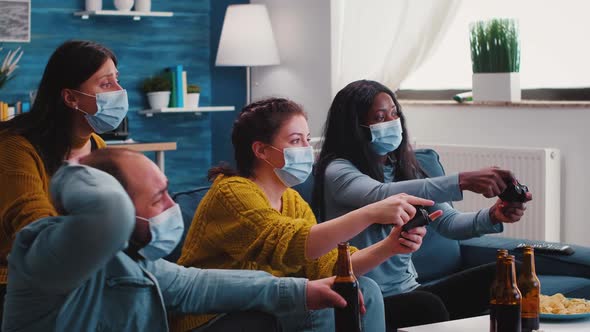 Friends with Masks Holding Controllers Playing Video Game alt