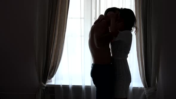Couple Kissing Near Window. alt