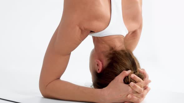 Senior Woman in White Space Practice Yoga Closeup Tilt Movement Showing a Head Stand