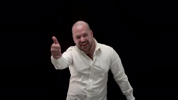 Bald Bearded Man in White Shirt Laughs at Camera, Shows His Fingers. A Businessman in Crumpled Shirt alt