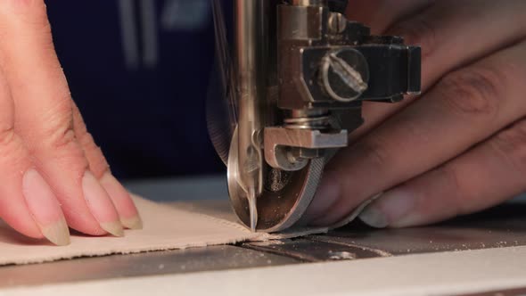 Manufacturing shoes in a shoe factory. Sewing shoes from natural leather (close-up) alt