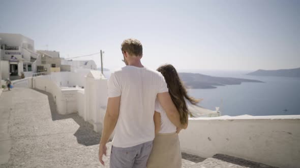 Tourist Couple Walking in Village on Santorini