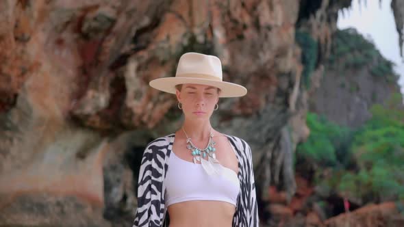 Young Woman in Hat Tonic and Swimsuit Posing Against Magnificent Rocks of Krabi Province alt