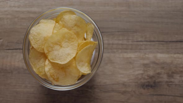 Potato chips in glass dish rotating on a table.