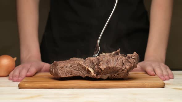 Woman sweeps fresh vegetables from the board and puts a piece of boiled meat alt
