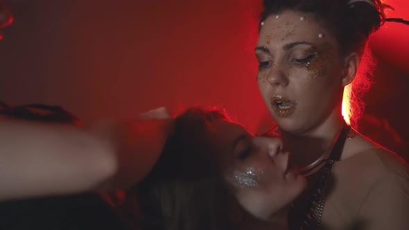 Close Up of Three Beautiful Models with Stylish Hair and Makeup Hugging on Red Background alt