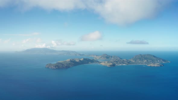 Aerial shot of mountainous islands surrounded by endless blue sea in Saint Kitts and Nevis alt