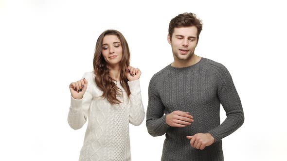 Slow-motion Young Couple in Sweaters Enjoy Dancing Celebrate for Christmas Fun Together Feeling