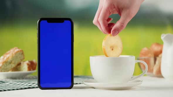 Smartphone with Blue Chroma Key Screen and Tea Cup Closeup alt