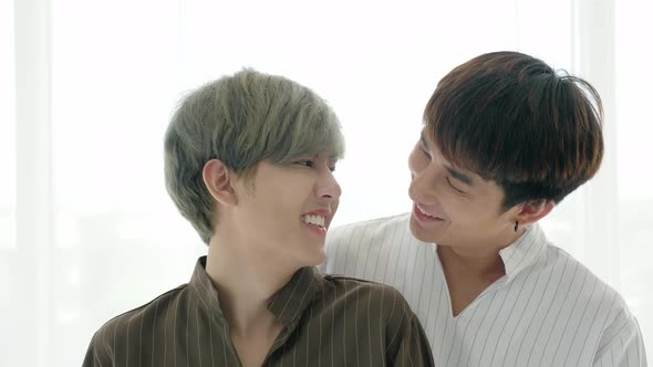 Asian gay couple, stand overlap, swife the dust off, make eye contact and smile alt