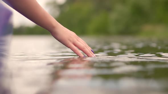 Hands Playing And Touching Water In Slow Motion. Woman Having Fun On Holiday Vacation Weekend Trip. alt
