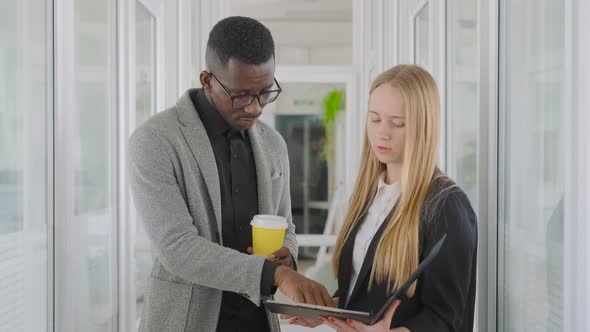 Multinational Business Team of Two People Man and Woman Talking in Office Hall