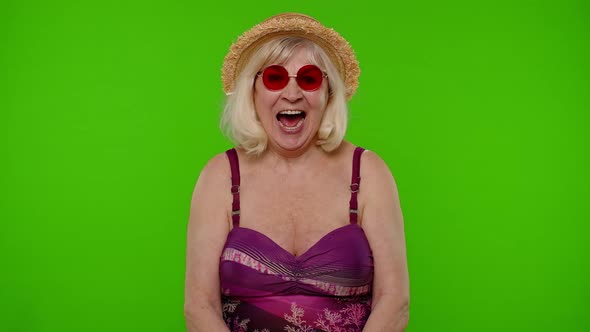 Amazed Senior Pensioner Woman Tourist in Swimsuit Shocked By Sudden Victory Saying Wow on Chroma Key alt