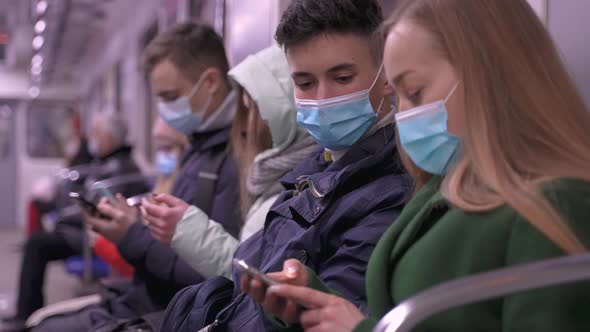 Masked Subway Passengers Using Phones in Transport alt