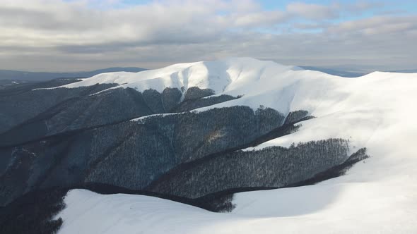 Amazing Aerial Flight Over Misty Mountain Range Meadows and Snow Covered Peaks in Winter Time alt