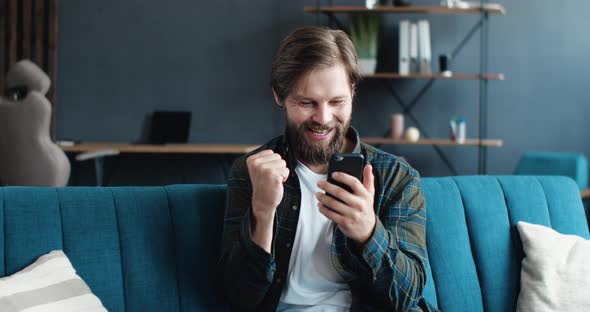 Extremely Happy Successful Man becoming Win, making sign og Winner with his Hand getting Emotions.