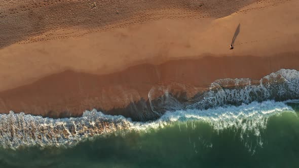 Aerial view of Praia dos Salgados with two people walking at the beach alt