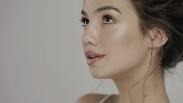 Girl with Lovely Smile Moisturizing Her T-zone and Touching Nose alt