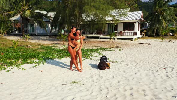 Modern Fun Women Traveling Spending Quality Time at The Beach on Summer White Sand and Blue alt