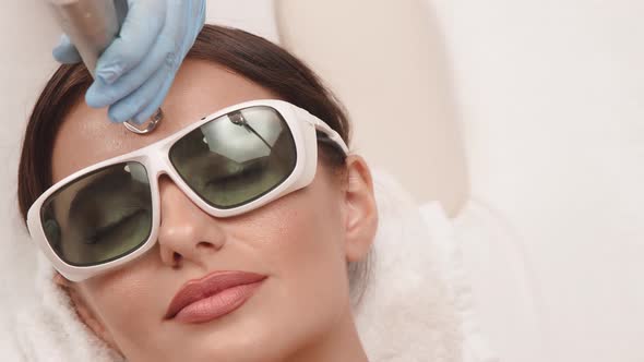 Close-up of Woman Face Receiving Erbium Laser Treatment alt