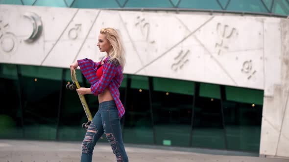 Attractive Teenage Girl Stepping on Skateboard and Rolling on Wide Space Area alt