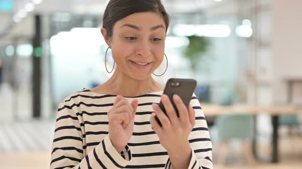 Portrait of Excited Indian Woman Celebrating Success on Smartphone  alt