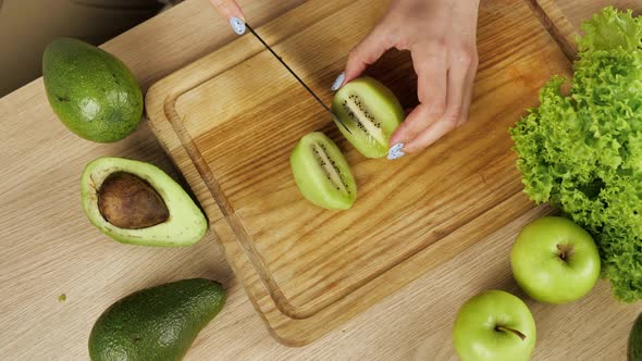 The Cook Cuts Pieces of a Kiwi alt