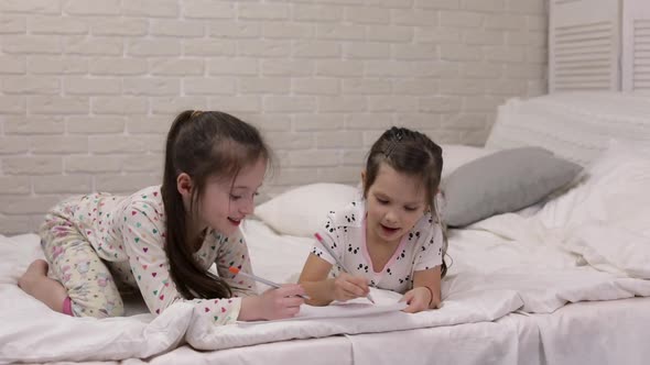 Kids Drawing Pictures While Lying on Bed