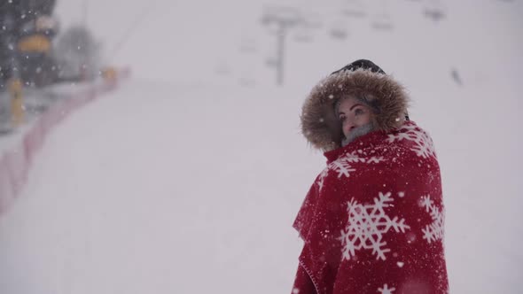 Close Up of Frozen Woman Wrapped in a Blanket at Snowstorm alt