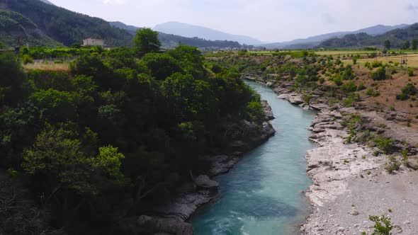 Stunning drone view of fresh waters of Vjosa river amidst beautiful green cliffs and mountains. Aeri alt