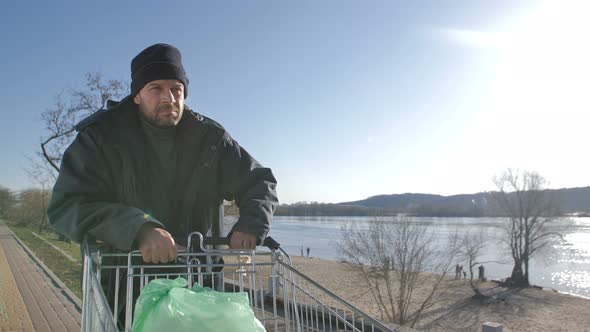 Portrait of Mature Homeless Man Walking Near River alt