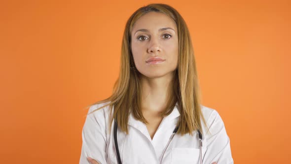 Portrait of Young Beautiful Female Doctor, Close Shot. Isolated on Orange Background, Studio Shot alt