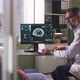 Mature Oncologist Explaining CT Image To Patient During Chemotherapy