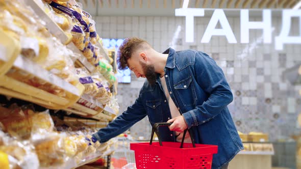 Man Buyer Choosing Fresh and Tasty Bread in the Grocery alt