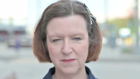 Close Up of Old Woman Face Looking at the Camera Outdoor alt