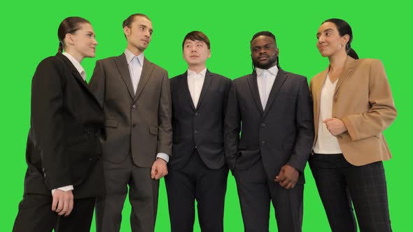 Group of Colleagues in Front of Camera Look at Each Other and Smile on a Green Screen Chroma Key alt