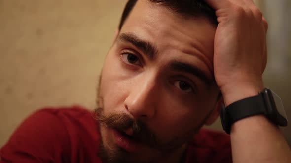 Macro Portrait of Drunk Hipster Suffering From Pain and Intoxication Touching His Face alt