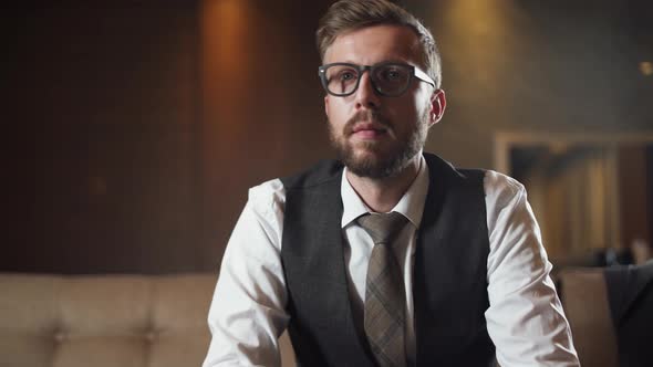 Young Businessman in Glasses Watches the News on TV and Turn on Channels, Man in the Suit Sitting on alt