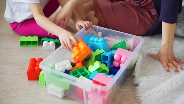 Little Girl with Mother Picking Up Toys Blocks alt